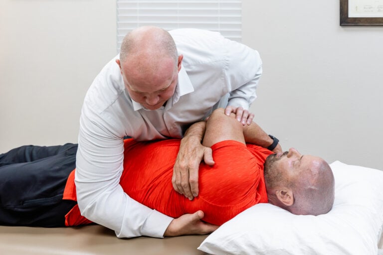 Osteopathic physician performing hands-on osteopathic manipulation on a patient lying on his side