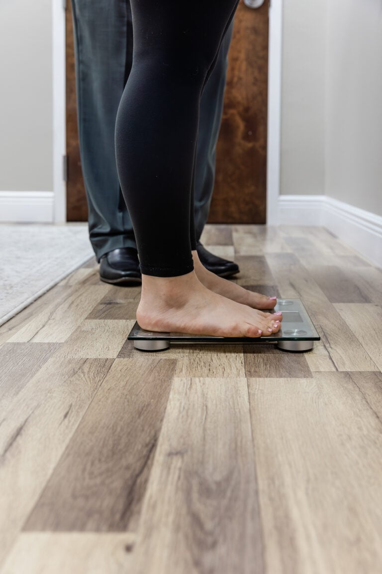 Patient stepping on a scale for a body composition check